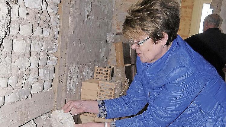 Eine Mauer mit Neustadter Geschichte: Elke Protzmann schaut sich die Gips-Formen aus der Puppenherstellung ganz genau an.