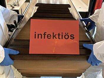 Menschen, die an Covid-19 verstorben sind, kommen in einen Sarg, der nicht mehr geöffnet werden darf und mit "infektiös" gekennzeichnet ist.