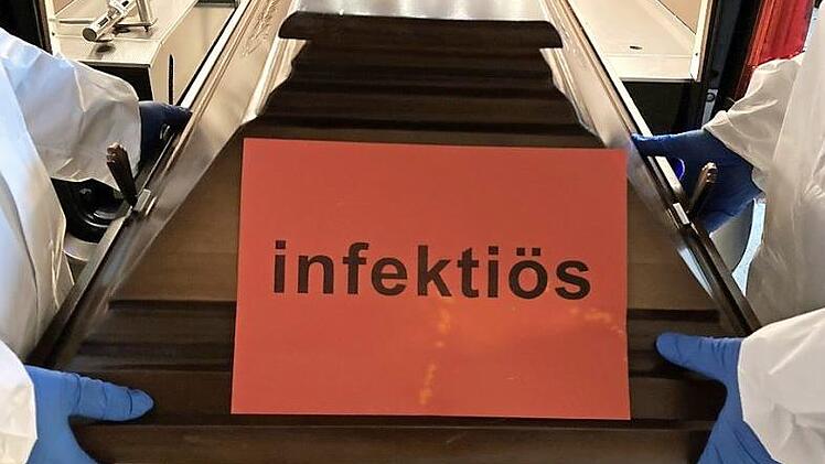 Menschen, die an Covid-19 verstorben sind, kommen in einen Sarg, der nicht mehr geöffnet werden darf und mit "infektiös" gekennzeichnet ist.