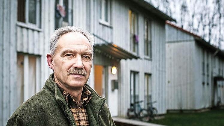 Harry Dittrich (59) ist Hausverwalter der Gemeinschaftsunterkunft in Kronach, die im Hintergrund zu sehen ist. Bei seiner Arbeit profitiert er vom Engagement Erhenamtlicher. Manchmal leidet er aber auch darunter.  Foto: Hendrik Steffens