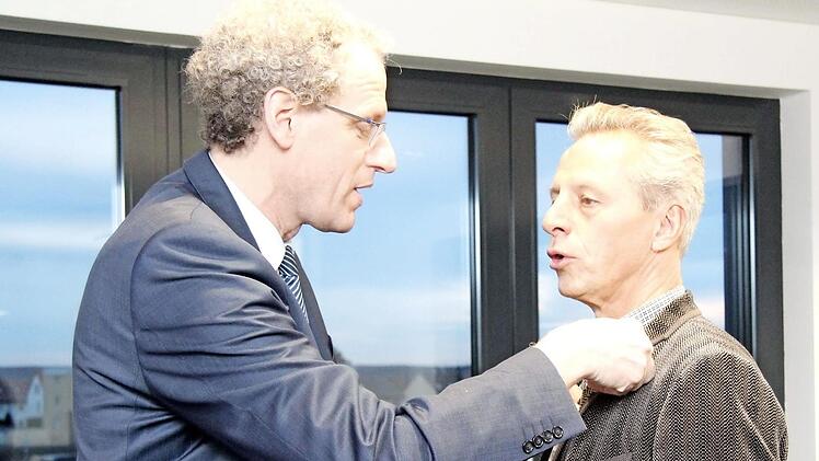 Bürgermeister German Hacker steckt Wolfgang Seel die Ehrennadel der Stadt Herzogenaurach an. Foto: Richard Sänger