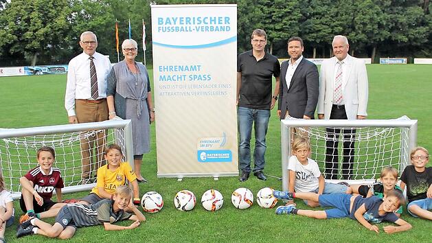 Thomas Buchta (hinten, Mitte) war der "Mann des Abends", als die Sportvereinigung auf die Erfolge der Fußballabteilung zurückblickte. Damit der Verein auch künftig nicht über Nachwuchsmangel klagen muss, stellte der Bayerischen Fußballverband in Person von Margot Härtlein (hinten, Zweite von links) und Siegfried Tabbert dem Verein Mini-Tore und Fußbälle zur Verfügung. Foto: Kurt Hinner