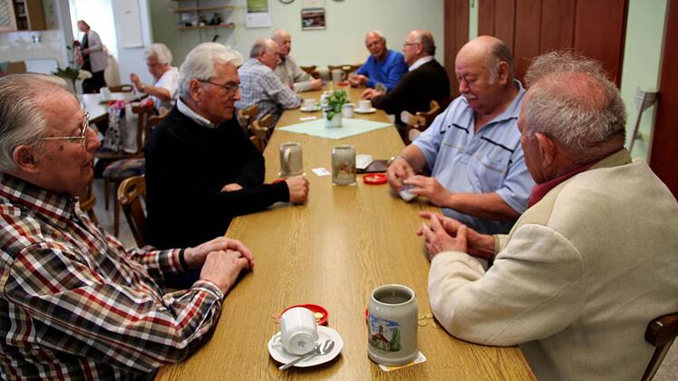 Die Herre spielen begeistert Schafkopf.