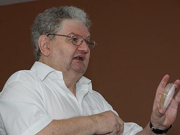 Alfons Rösch hält eine Petrischale mit Bakterien hoch, die als Transportorganismen für Gene genutzt werden. Foto: Arkadius Guzy