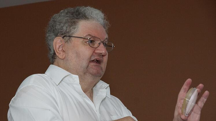 Alfons Rösch hält eine Petrischale mit Bakterien hoch, die als Transportorganismen für Gene genutzt werden. Foto: Arkadius Guzy