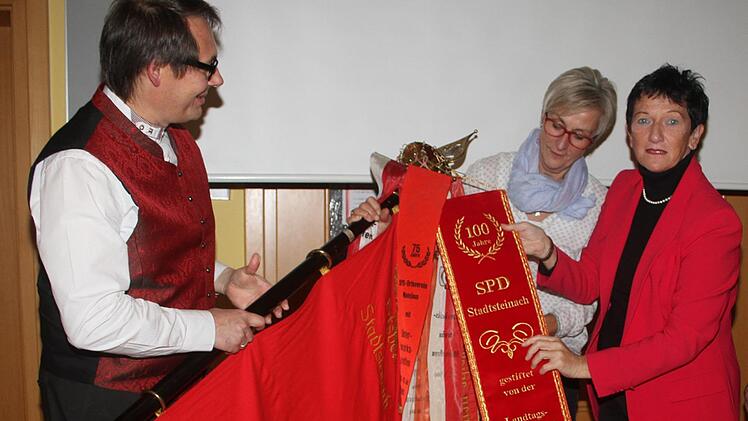 Die Kreisvorsitzende der SPD, Inge Aures, heftete an die Fahne des SPD-Ortsvereins ein Fahnenband an: B&uuml;rgermeister Roland Wolfrum, der erste SPD-B&uuml;germeister in Stadtsteinach seit Bestehen der Partei, und die erste weibliche SPD-Stadtr&auml;tin Karin Witzgall freuten sich.Sonny Adam