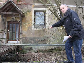 Norbert Drechsler zeigt, wie die Köderbox (unterhalb des Aufgangs) gesichert wird: Sie wird verschraubt, so dass der Deckel nicht von anderen Tieren geöffnet werden kann. Außerdem werden die Boxen an Holzstäben befestigt, damit sie das Wasser nicht wegspülen kann. Fotos: Sonja Adam