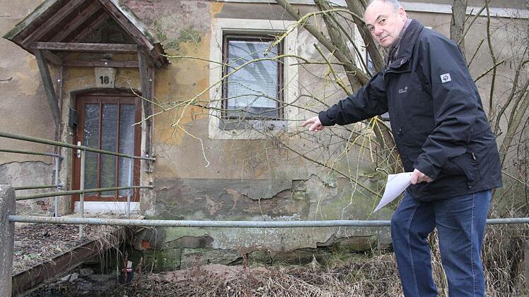 Norbert Drechsler zeigt, wie die Köderbox (unterhalb des Aufgangs) gesichert wird: Sie wird verschraubt, so dass der Deckel nicht von anderen Tieren geöffnet werden kann. Außerdem werden die Boxen an Holzstäben befestigt, damit sie das Wasser nicht wegspülen kann. Fotos: Sonja Adam