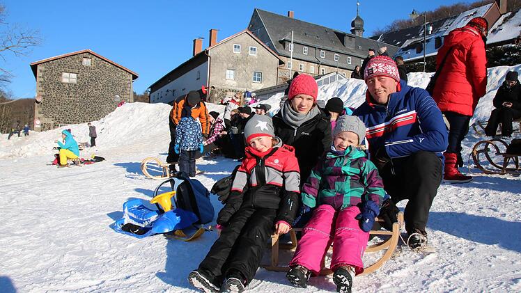 Angelika und Michael Hohmann haben sich mit ihren Kindern Lisa und Mona die Klosterwiese unterhalb des Klosters Kreuzberg zum Rodeln ausgesucht. Die Familie aus Herschfeld war begeistert. Foto: Ralf Ruppert