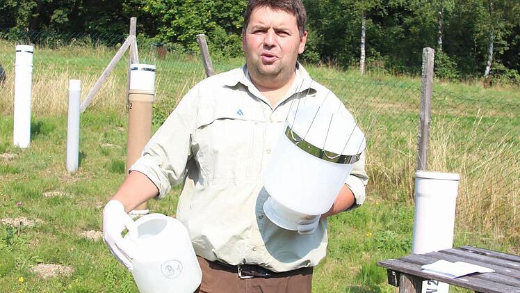 In den Behältern, in denen das Regenwasser für die chemische Analyse gesammelt wird, ist höchstens ein Fingerhut voll. 20 Milliliter würde Marcus Hollederer für das Abfüllen einer Probe brauchen.  Foto: Friedwald Schedel