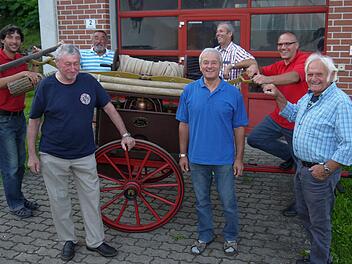 Treffpunkt für alle Feuerwehr-Generationen: An der 1875 Tremersdorfer in Dienst gestellten Spritze der Tremersdorfer Feuerwehr reden Frank Fischer, Bernd Fischer, Manfred Fischer, Hans Fischer, Walter Flohrschütz, Michael Truckenbrodt und Gerhardt Oppel (von linkls) über gute und schlechte Zeiten in der Zusammenarbeit zwischen Tremersdorf und Rottenbach. Foto: Berthold Köhler
