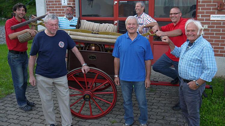 Treffpunkt für alle Feuerwehr-Generationen: An der 1875 Tremersdorfer in Dienst gestellten Spritze der Tremersdorfer Feuerwehr reden Frank Fischer, Bernd Fischer, Manfred Fischer, Hans Fischer, Walter Flohrschütz, Michael Truckenbrodt und Gerhardt Oppel (von linkls) über gute und schlechte Zeiten in der Zusammenarbeit zwischen Tremersdorf und Rottenbach. Foto: Berthold Köhler