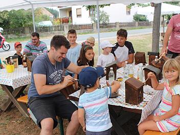 Integration beginnt schon bei den Kleinsten: Sascha Link (vorne Mitte), Torsten Albrecht (hinten rechts) und dessen Sohn Marvin (links daneben) helfen im Ferienprogramm beim Nistkästenbau.     Foto: Yannick Hupfer