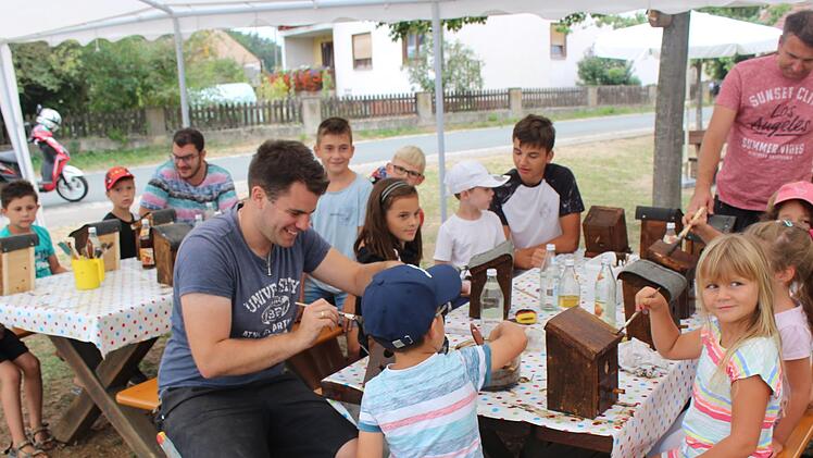 Integration beginnt schon bei den Kleinsten: Sascha Link (vorne Mitte), Torsten Albrecht (hinten rechts) und dessen Sohn Marvin (links daneben) helfen im Ferienprogramm beim Nistkästenbau.     Foto: Yannick Hupfer