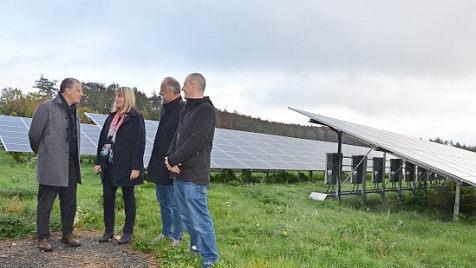 Wilhelm Austen, Birgit Weber, Stefan Schneidawind und Johannes Balk stehen vor den Modulen im Solarpark Motschental.