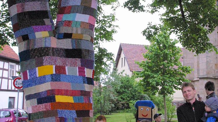 Selbst den Jüngsten gefällt die schick in Strick gehüllte Dorflinde in Gemünda. Foto: Bettina Knauth