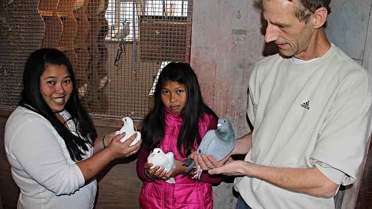 Von seinem Vater Harry hat Frank Schelhorn (rechts) die Liebe zu Tauben geerbt. Er freut sich, dass auch seine Frau Benjaporn und seine Stieftochter Wilawan (von links) gerne mitmachen.  Foto: Helmut Will