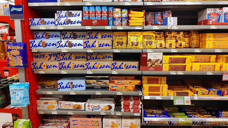 Regale voller Kekse und Snacks einer bekannten deutschen Marke. Verpackungen in Gelb und Blau dominieren. Produkte umfassen Leibniz und Bahlsen, Outlet in der Nähe von Bamberg bald eröffnet.