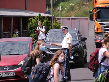 Das Foto, im Juni aufgenommen, zeigt wie Olaf Gräf von der Kissinger Polizei an der Außenstelle der Sinnberg-Grundschule auf das eingeschränkte Halteverbot hinweist, in dem Eltern nach Schulschluss stehen, um auf ihre Kinder zu warten.  Ab Dienstag beginnt offiziell wieder die Schule.  Foto: Archiv/Benedikt Borst