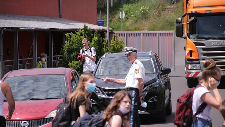Das Foto, im Juni aufgenommen, zeigt wie Olaf Gräf von der Kissinger Polizei an der Außenstelle der Sinnberg-Grundschule auf das eingeschränkte Halteverbot hinweist, in dem Eltern nach Schulschluss stehen, um auf ihre Kinder zu warten.  Ab Dienstag beginnt offiziell wieder die Schule.  Foto: Archiv/Benedikt Borst