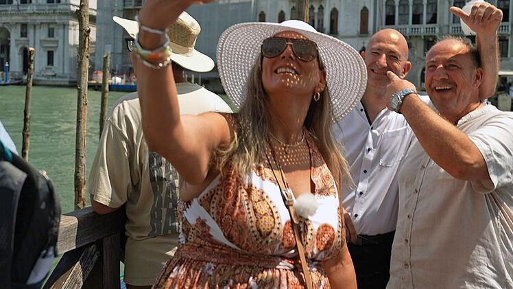 Ist er's oder ist er's nicht? Nicole und Sascha (rechts) Fingerhuth glauben zu tr&auml;umen, als mitten in Venedig pl&ouml;tzlich Jeff Bezos (Mitte) vor ihnen steht.  Und, tja, es ist auch nur ein Traum. Denn es ist nur ein Doppelg&auml;nger.