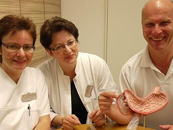 Ernährungsberaterin Sabine Lamprecht (von links), Internistin Elisabeth Dewald und Chefchirurg Bernhard Drummer demonstrieren den Eingriff am Magenausgang.  Foto:  Pauline Lindner