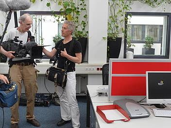 Das Filmteam im Großraumbüro bei den Dreharbeiten in  der Bamberger Lokalredaktion. Links im Bild Jan Betke, der für den Ton zuständig ist, daneben Kameramann Klaus Lautenbacher und Regisseur Matti Bauer. Rechts im Hintergrund ist  Chefreporter Michael Wehner an seinem Arbeitsplatz zu sehen.  Foto: Ronald Rinklef