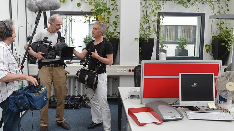 Das Filmteam im Großraumbüro bei den Dreharbeiten in  der Bamberger Lokalredaktion. Links im Bild Jan Betke, der für den Ton zuständig ist, daneben Kameramann Klaus Lautenbacher und Regisseur Matti Bauer. Rechts im Hintergrund ist  Chefreporter Michael Wehner an seinem Arbeitsplatz zu sehen.  Foto: Ronald Rinklef