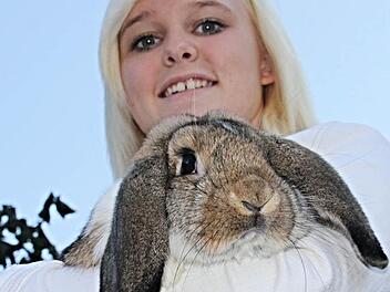 Frisch auf den Namen "Henriette" getauft, hält die junge Züchterin aus Lahm, Marina Schmidt, ihren kuscheligen Deutschen Kleinwidder im Arm, der sich an sie schmiegt und treuherzig in die Kamera blickt.  Foto: Helmut Will