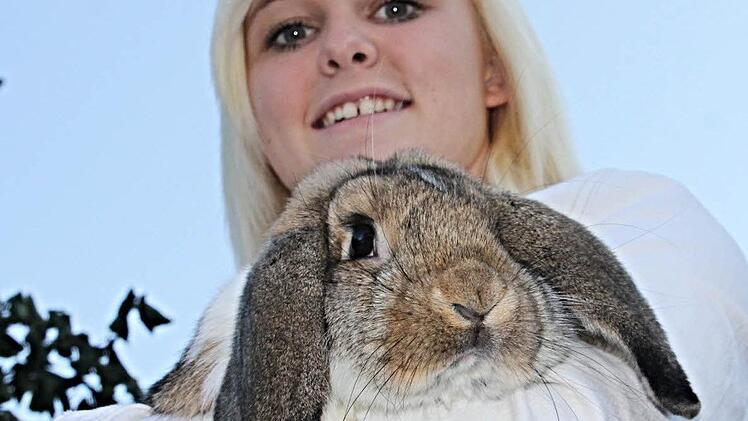 Frisch auf den Namen "Henriette" getauft, hält die junge Züchterin aus Lahm, Marina Schmidt, ihren kuscheligen Deutschen Kleinwidder im Arm, der sich an sie schmiegt und treuherzig in die Kamera blickt.  Foto: Helmut Will