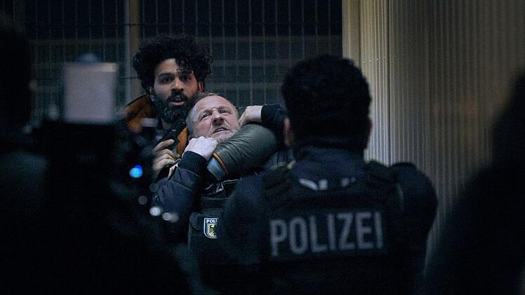 Geiselnahme aus Verzweiflung: Joon Rostami (Altamasch Noor, links) bedroht Roland Orbach (Maximilian Brückner) mit einer Waffe.