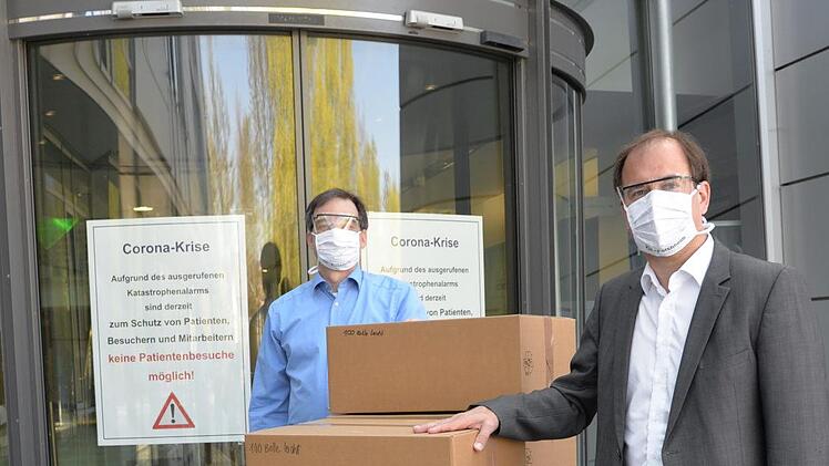 Prokurist Oliver Amon (l.)  dankt Dietmar Drummer f&uuml;r die Lieferung von 1000 Schutzbrillen. Foto: PR
