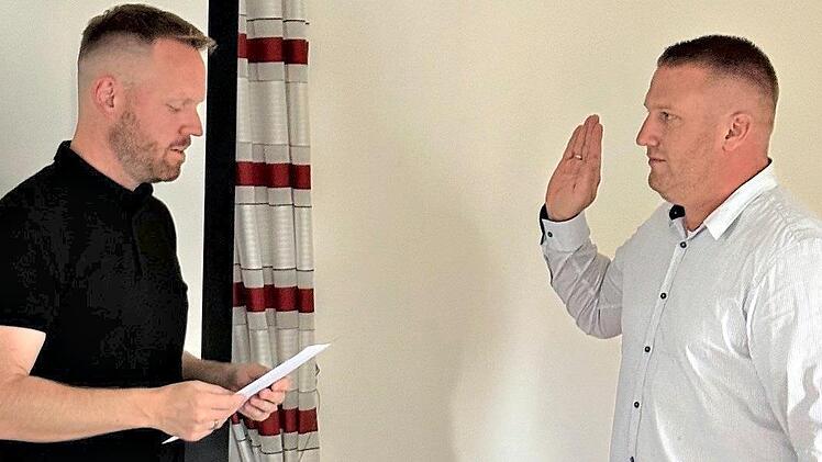 B&uuml;rgermeister Simon Fischer (l.) vereidigt den neuen Gemeinderat Harald Schorr. Birgit V&ouml;lker