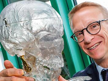 Oliver Brehm mit einem Kunststoff-Skelett, das mit Endoprothesen der Peter Brehm GmbH ausgestattet ist  Fotos: Matthias Hoch