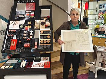 Alexandra Hofmann mit der Gründungsurkunde aus dem Jahr 1860, als ihr Ururgroßvater den Grundstein für den Laden im Kressenstein gelegt hat. Foto: Christine Fischer