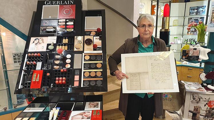 Alexandra Hofmann mit der Gründungsurkunde aus dem Jahr 1860, als ihr Ururgroßvater den Grundstein für den Laden im Kressenstein gelegt hat. Foto: Christine Fischer