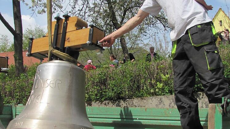 Thorsten Riedel von der Fa. Bayreuther Turmuhren vertäut die neuen Glocken, bevor sie von einem Kran auf den Seidmannsdorfer Kirchturm gehievt werden. Foto: Martin Koch