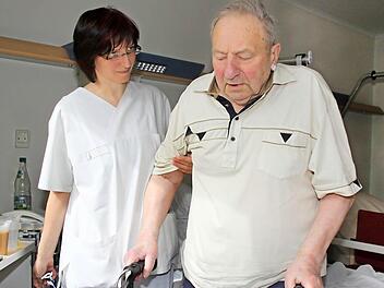 Mit ein bisschen Unterstützung von Krankenschwester Gabriele Schott schafft Alfred Dietz es wieder, die ersten Schritte mit dem Rollator zu gehen. Vom Zimmer auf den Klinikflur und zurück - nicht viel, aber ein Anfang, über den der 79-Jährige sehr froh ist. Foto: Dagmar Besand