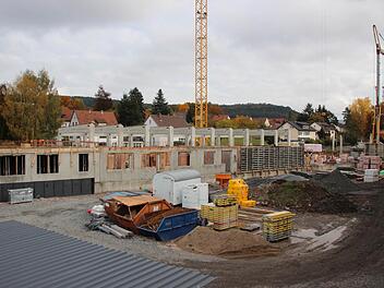 Blick von der Fußgängerbrücke auf den Feuerwehrkomplex. Für die Feuerwehr Kronach sind die Fahrzeughallen - zu erkennen an den hohen Betonträgern - und die beiden linken Bereiche der Betonwände vorgesehen. Ab der eingeschalten Außenwand - hinter den gelb eingepackten Teilen - beginnt der Landkreisteil, der nach rechts noch weiter vorangetrieben wird.  Foto: Friedwald Schedel