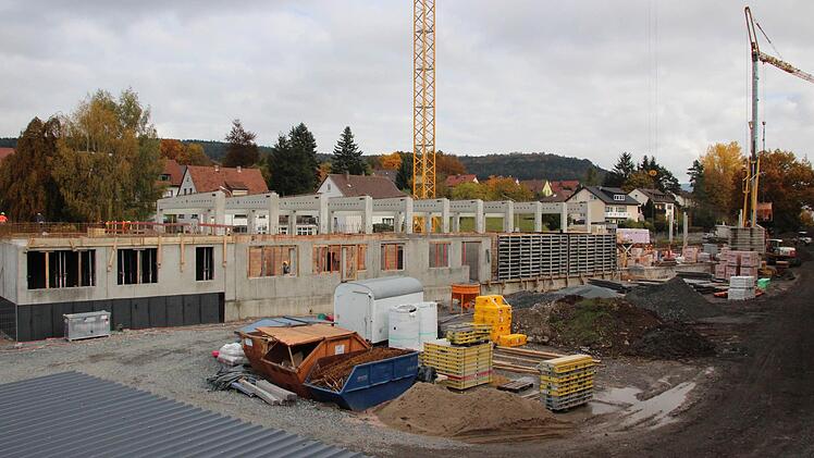 Blick von der Fußgängerbrücke auf den Feuerwehrkomplex. Für die Feuerwehr Kronach sind die Fahrzeughallen - zu erkennen an den hohen Betonträgern - und die beiden linken Bereiche der Betonwände vorgesehen. Ab der eingeschalten Außenwand - hinter den gelb eingepackten Teilen - beginnt der Landkreisteil, der nach rechts noch weiter vorangetrieben wird.  Foto: Friedwald Schedel
