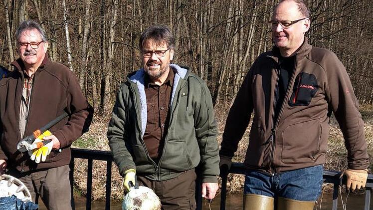 Wolfgang Ebert (von links), Manfred Häfner und Carsten Höfer präsentieren während einer kurzen Pause auf der Wernarzer Brücke einen Teil ihrer "Beute". Am Ende waren die Müllsäcke prall gefüllt. Foto: Karlheinz Franz