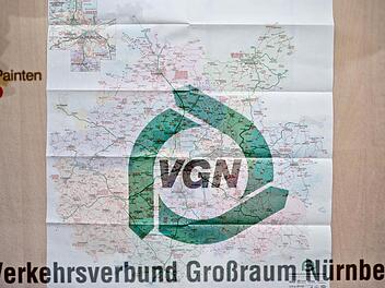 Das Logo des Verkehrsverbundes Großraum Nürnberg (VGN) über einer Karte des aktuellen Gesamtraum des VGN-Verkehrsnetzes Archivbild: Daniel Karmann/dpa