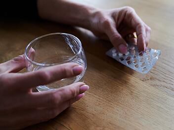 Frau h&auml;lt Tabletten in der Hand