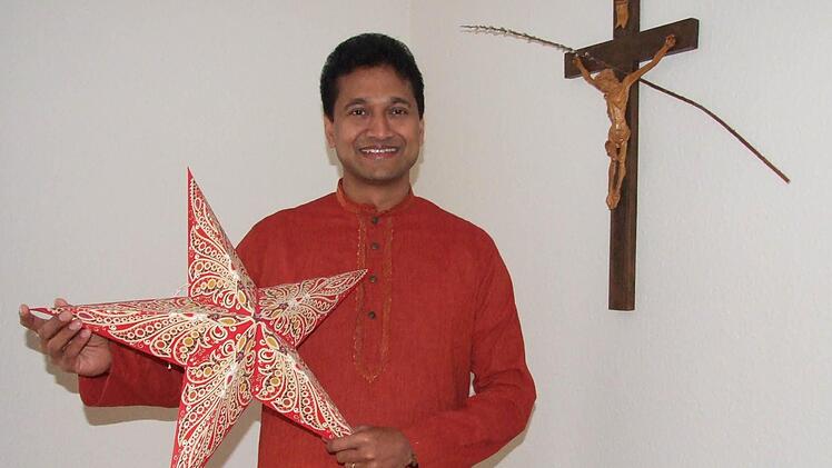 Der Stern ist in Indien das Weihnachtssymbol schlechthin. Pater Augustin Parambakathu im traditionellen indischen Männer-Gewand, bestehend aus dem Oberteil genannt ,Jhuba' und dem Unterkleid namens ,Mundu' mit einem modernen indischen Weihnachtsstern. Foto: Eckert