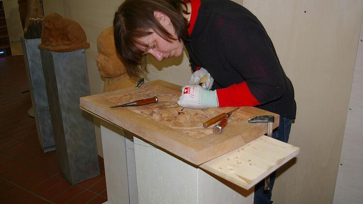 Bildhauerin Anja Hartmann zeigt die Arbeit an einem Relief-Bild.