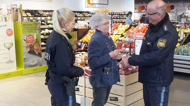 "So geht es nicht", sagt Polizeihauptkommissar Manfred Schneider (rechts) zu Helma Ritter (Bildmitte), die auf diesem gestellten Foto ihre Geldbörse zu Demonstrationszwecken einfach in die Jackentasche gesteckt hat. Polizeioberwachtmeisterin Vanessa Wießner beobachtet die Szene. Foto: Rolf Pralle