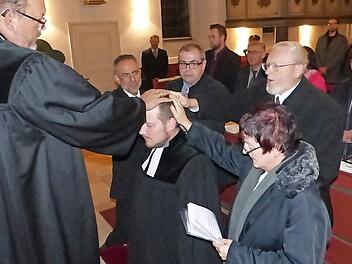Dekan Kretzschmar segnete mit Verantwortlichen der vier zur Pfarrei Untersteinach gehörenden Kirchengemeinden durch Handauflegen Pfarrer Martin Fleischmann (kniend).  Foto: kpw