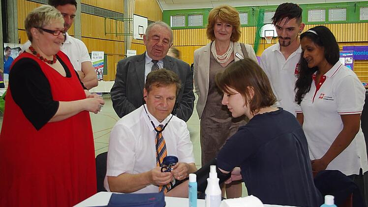 (von links) MdL Hermann Imhof misst den Blutdruck von MdB Emmi Zeulner.  Foto: Heike Schülein