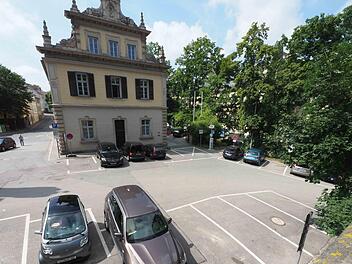 Ein Blick von den Arkaden auf den Platz, der umgestaltet werden soll. Im Hintergrund ist das Marstallgeb&auml;ude zu sehen. An drei von vier Seiten des Platzes befinden sich derzeit Kurzzeit- und Anwohnerstellpl&auml;tze. Foto: Christoph Winter