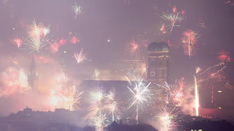 Feuerwerksraketen explodieren in der Silvesternacht &uuml;ber der Frauenkirche und der Innenstadt. Foto: Matthias Balk/dpa